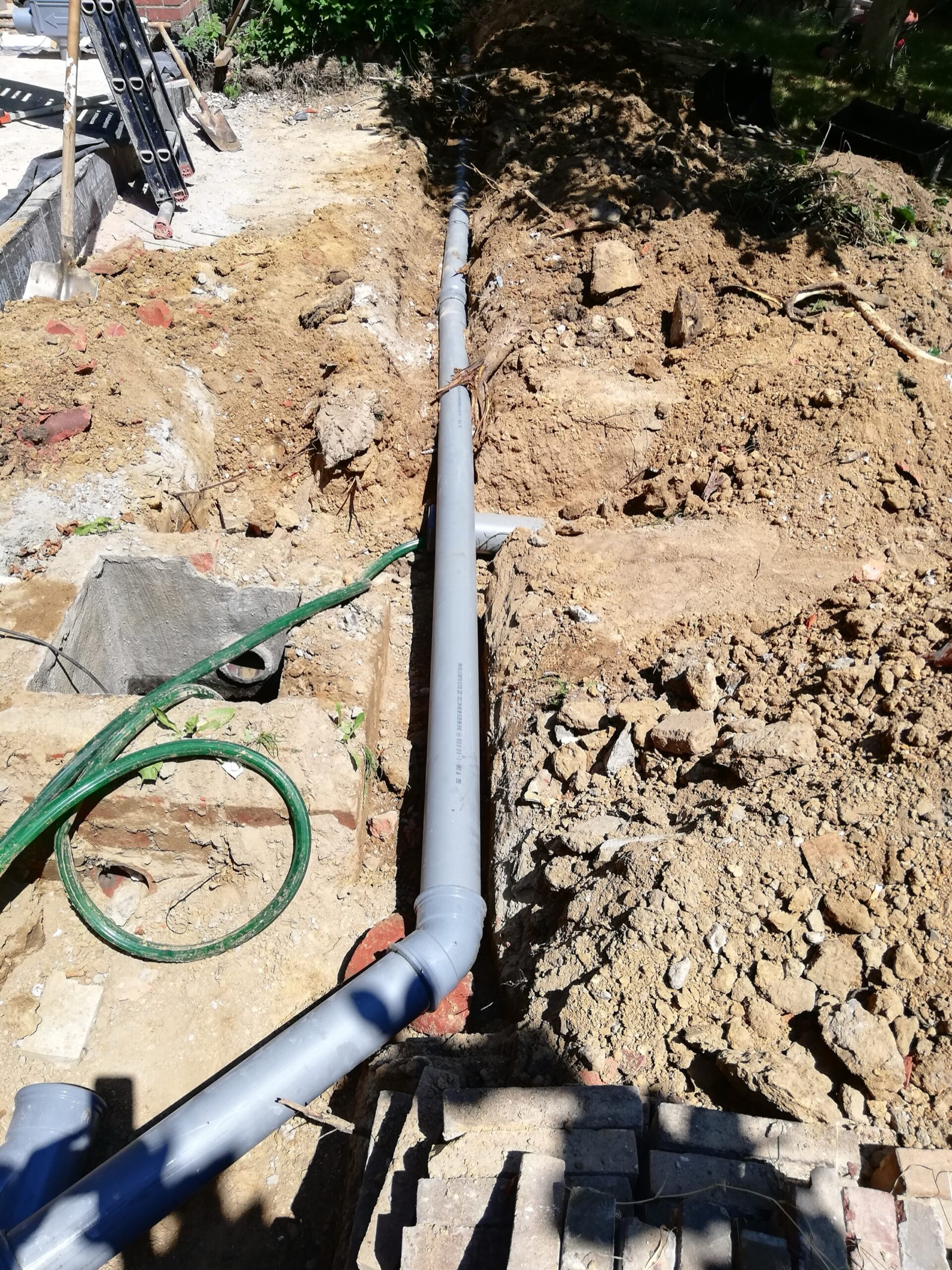 Mini-graafmachine graaft een rioleringssleuf