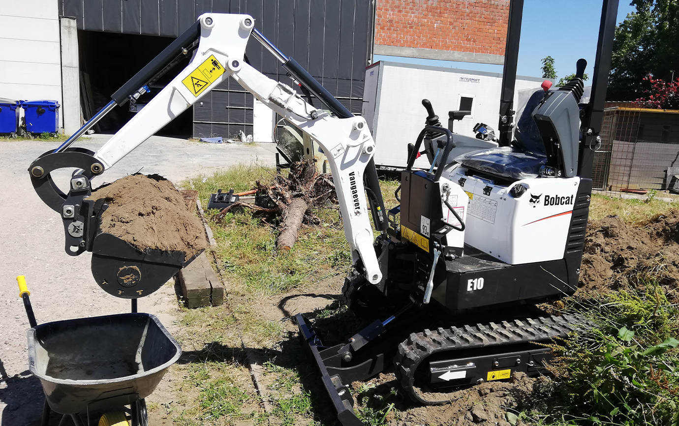 Witte Bobcat E10 mini-graafmachine op de werf